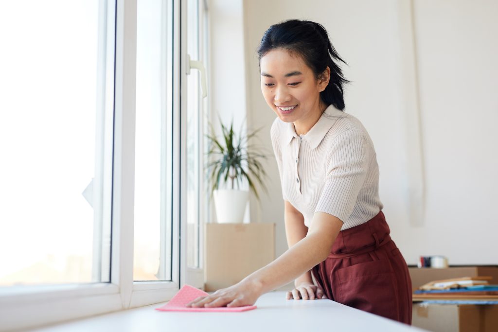 A new domestic helper wiping down a kitchen counter in a Singapore home on her first day of work.