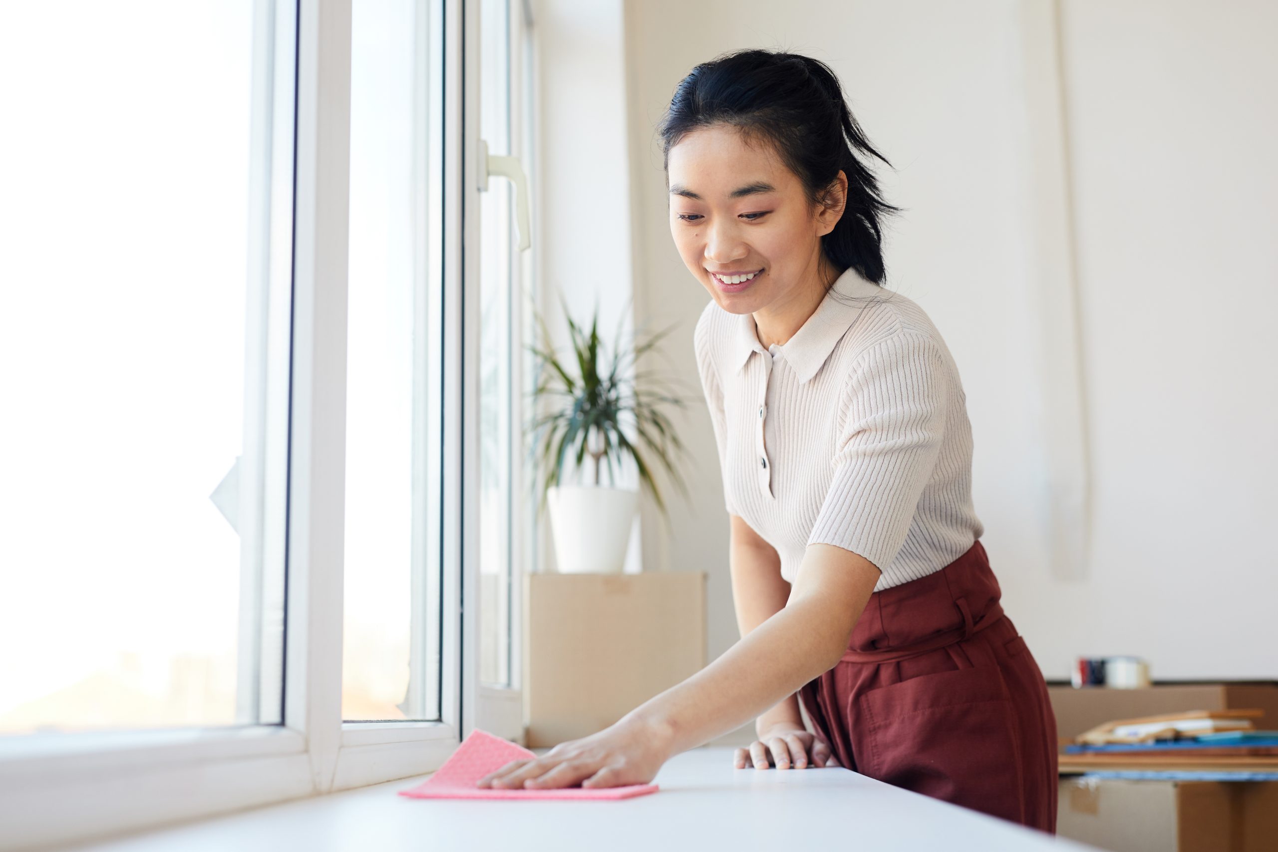 A new domestic helper wiping down a kitchen counter in a Singapore home on her first day of work.